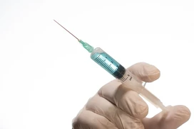 closeup-person-with-latex-glove-holding-needle-syringe-isolated-white-background.png