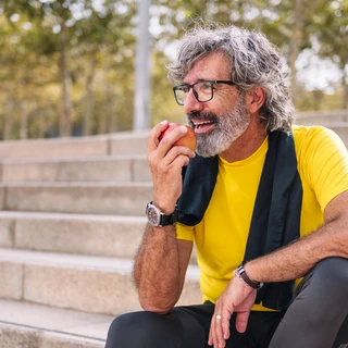 Mężczyzna je jabłko po zabiegu All-on-4