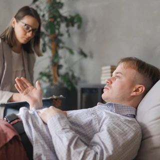 Kobieta psychiatra słucha pacjenta podczas konsultacji dotyczącej leczenia CHAD.