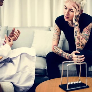 Przygnębiona kobieta na sesji terapeutycznej w ramach leczenia nerwicy.