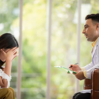 Lekarz omawia ze starszym pacjentem postępy w leczeniu schizofrenii.