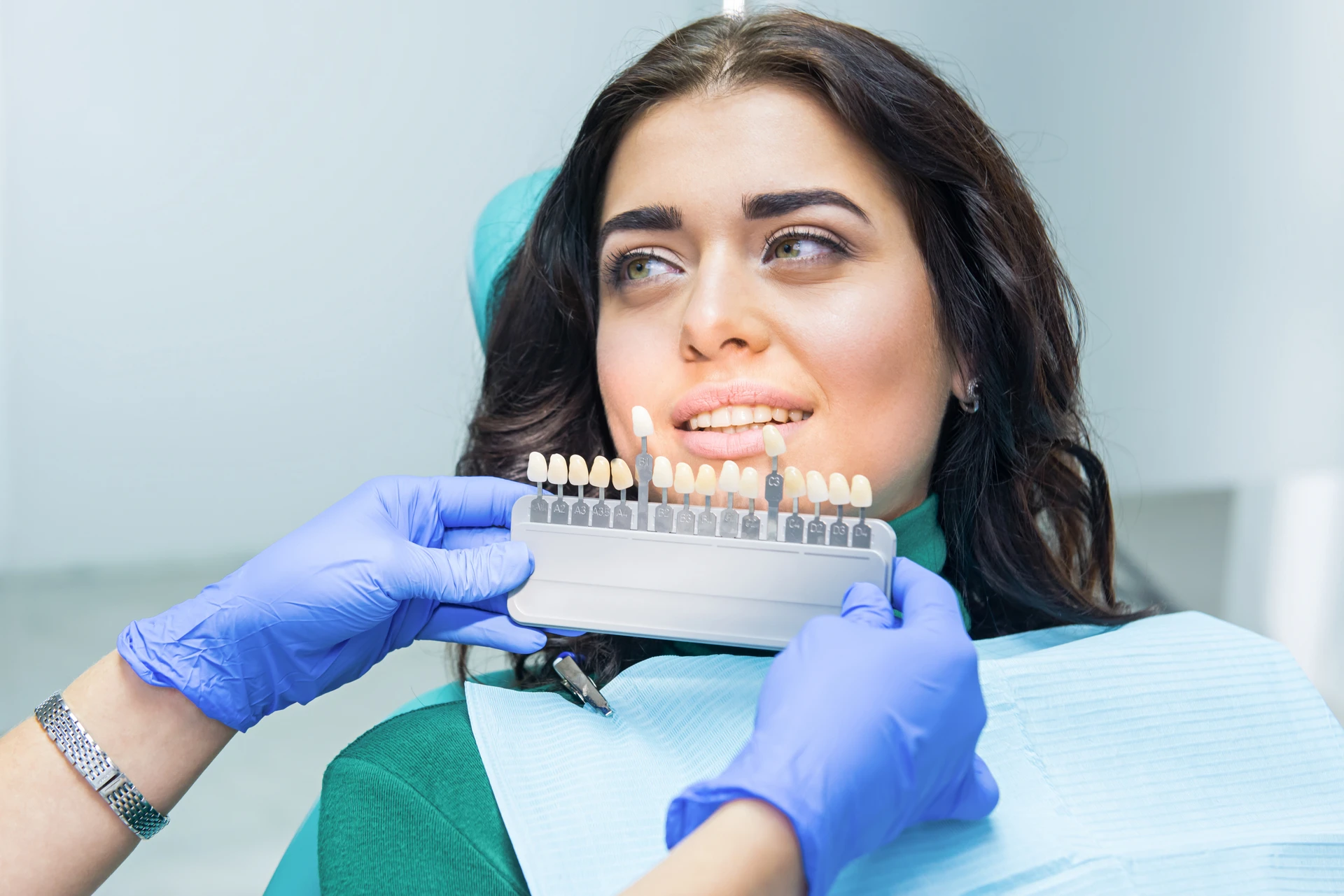 Stomatolog przeprowadza zbieg zakładania licówek na zęby