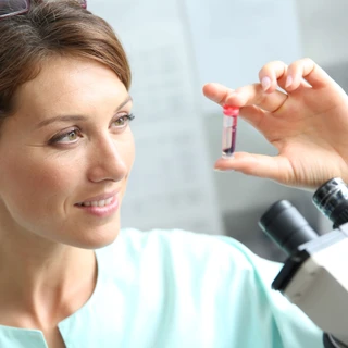 Laborantka trzyma fiolkę z krwią