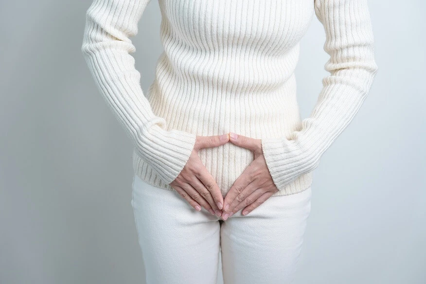Kobieta trzyma ręce na brzuchu