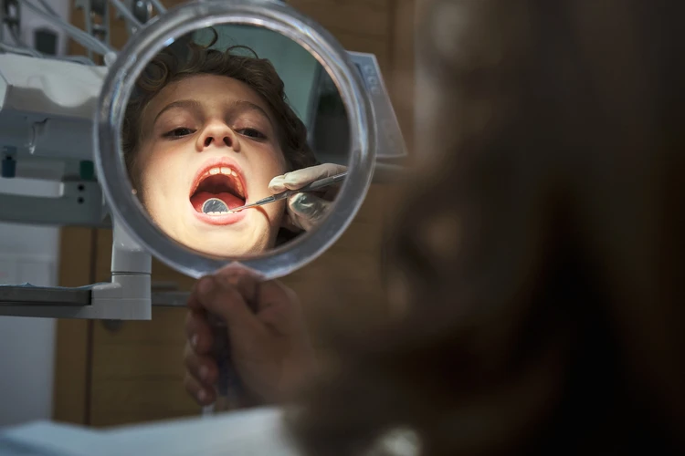 Dziecko podczas badania jamy ustnej u dentysty 