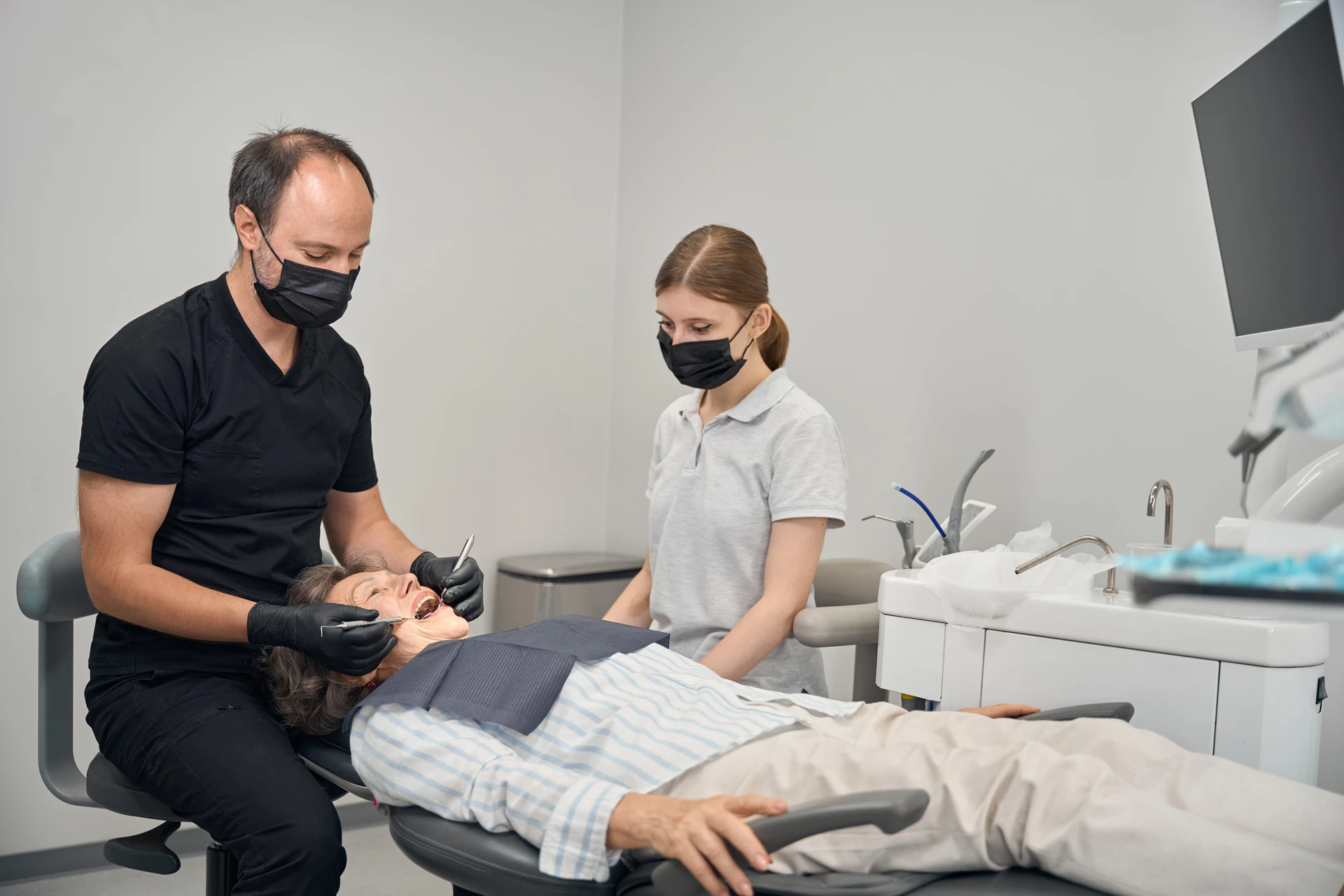 Protetyk przygotowuje pacjentkę do założenia protezy zębowej