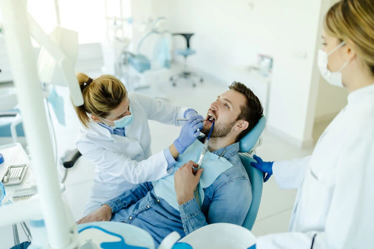 Mężczyzna na fotelu dentystycznym podczas leczenia zębów u stomatologa
