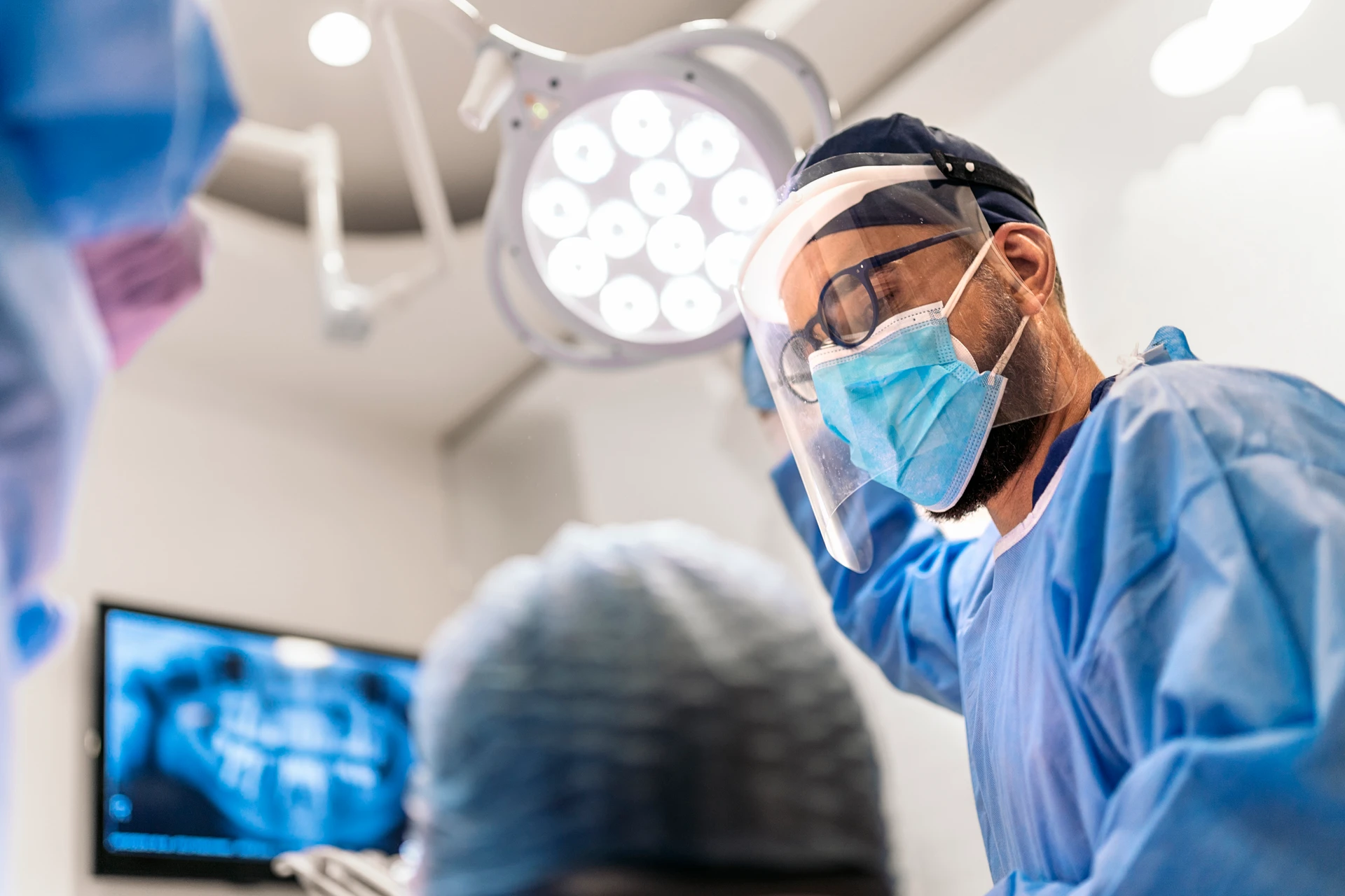 Pracownik kliniki w masce przygotowuje się do zabiegu przeszczepu dziąsła