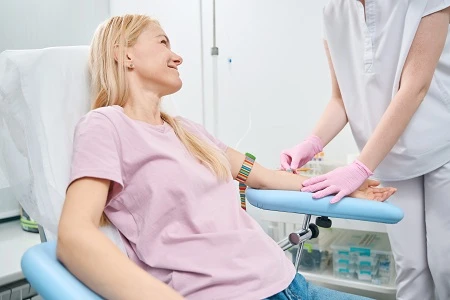 Pielęgniarka przygotowuje ramię pacjentki do pobrania krwi