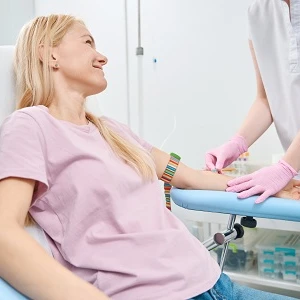 Pielęgniarka przygotowuje ramię pacjentki do pobrania krwi