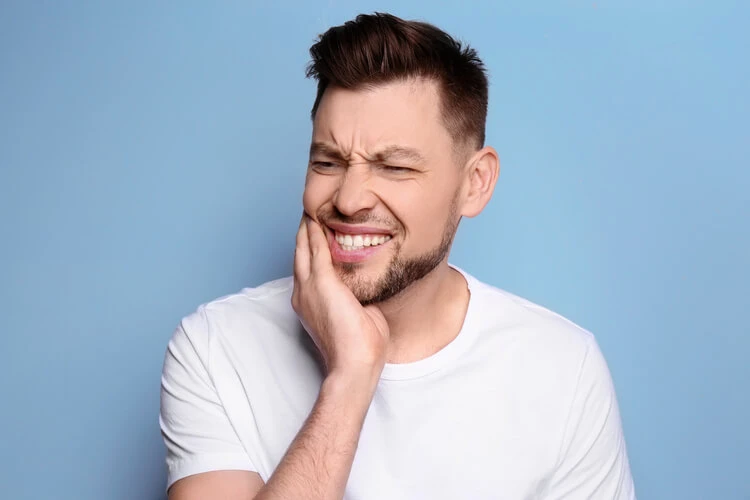 Mężczyzna trzymający się za żuchwę