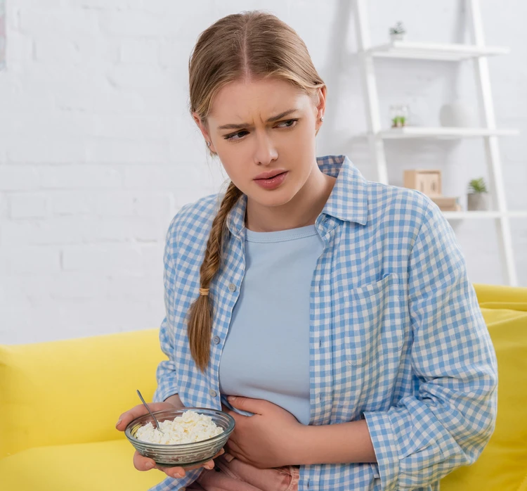 Kobieta cierpi na ból brzucha po posiłku