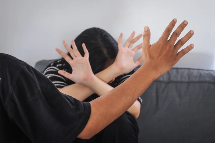 Kobieta zasłaniająca się przed ręką mężczyzny