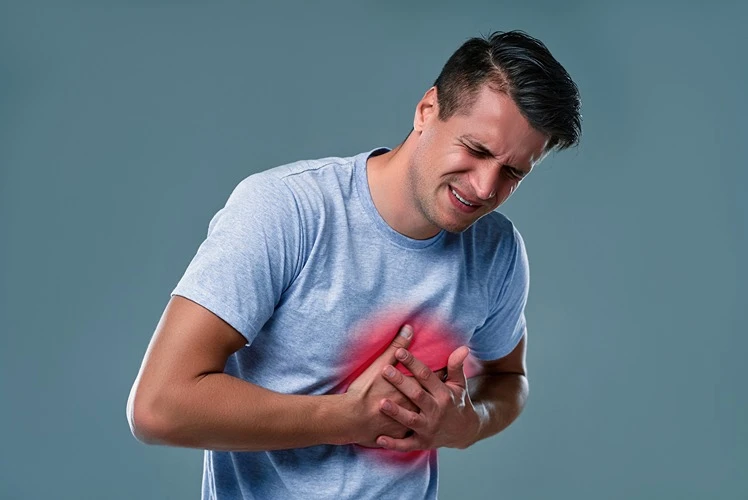 Mężczyzna trzymający się za klatkę piersiową z bólu