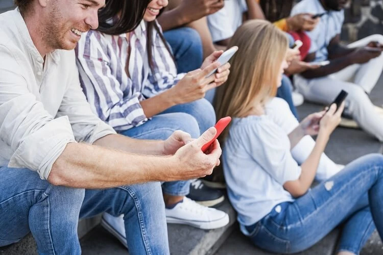 Grupa ludzi na dworze ze smartfonami w rękach