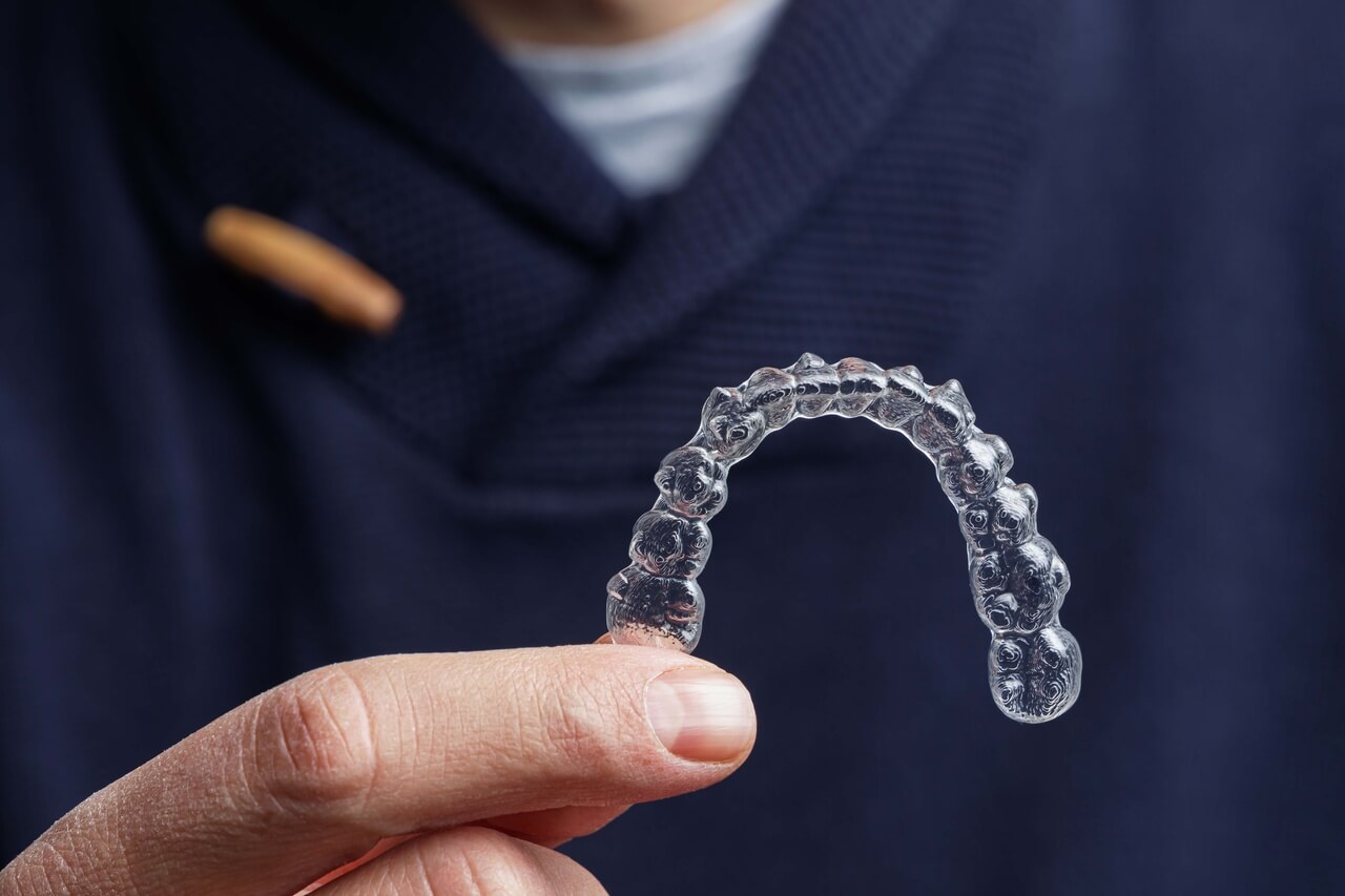 Lekarz stomatolog pokazuje aparat Invisalign